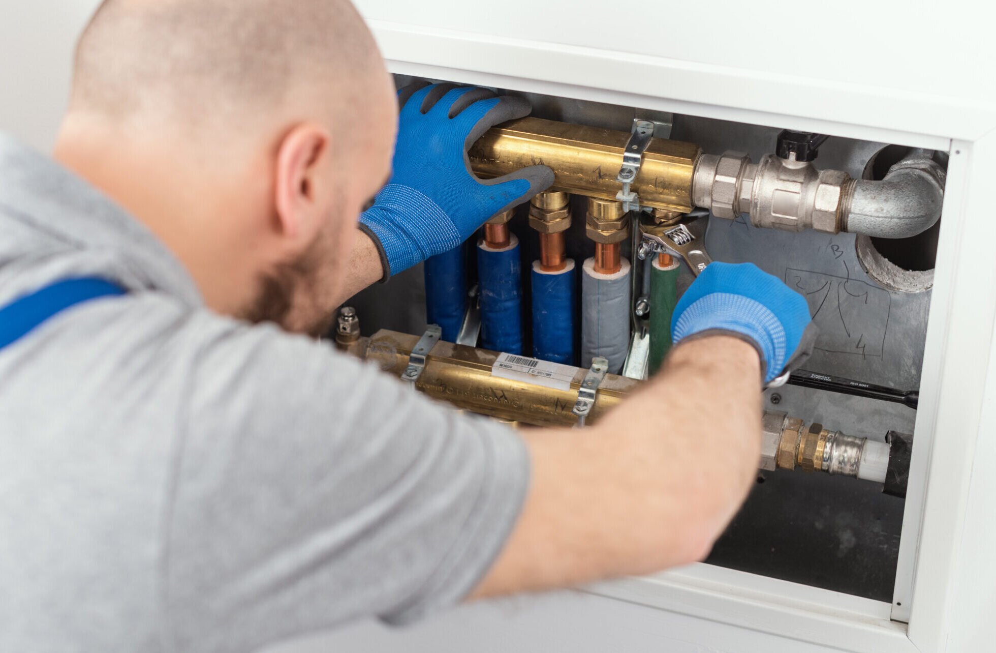 Professional plumber installing plumbing manifolds